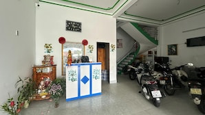 Una habitación con una recepción, una escalera y varias motocicletas estacionadas.