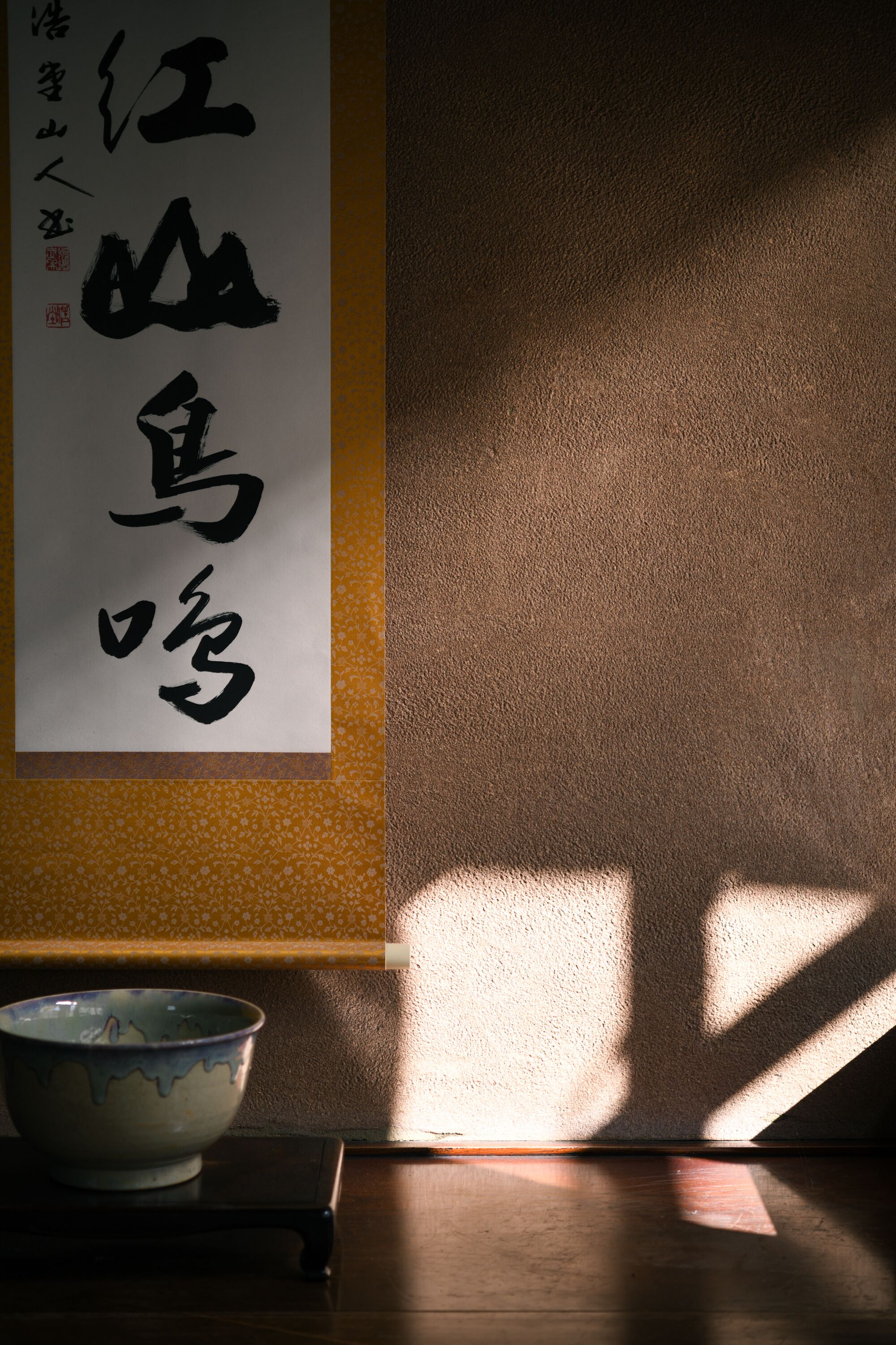 Et traditionelt japansk rum med tatamimåtter, en shoji-skærm og en kalligrafisk vægtekst.
