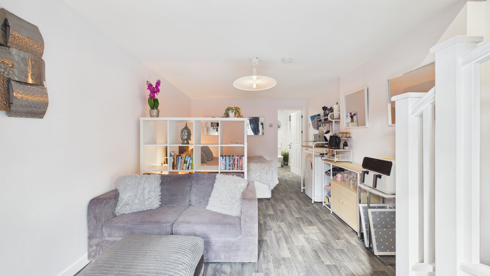 A modern living room with a sofa, a bookshelf, and a coffee table.
