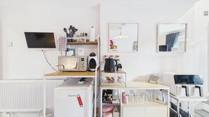 A compact kitchenette with a microwave, kettle, and coffee maker. - Portway Nook - 1 Bed Studio - Bishopston (Swansea)