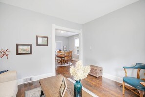 A spacious living room with hardwood flooring, a dining area with a wooden table and chairs, and a hallway leading to another room. - 3 Bedroom 2 bath home near Notre Dame(123ND) (South Bend)