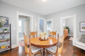A dining area with a round wooden table, six chairs, and a central vase with flowers. - 3 Bedroom 2 bath home near Notre Dame(123ND) (South Bend)