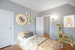 A bedroom with a bed, a bedside table, a mirror, and a wall-mounted shelf with toys. - 3 Bedroom 2 bath home near Notre Dame(123ND) (South Bend)