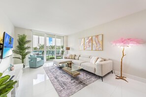 A modern living room with a white sofa, a glass coffee table, and a large floor lamp.
