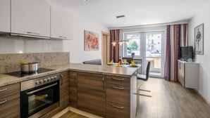 Eine moderne Küche mit Backofen, einer großen Kochinsel mit Spüle und einem Essbereich mit einem Stuhl.