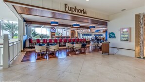 Un hall d’entrée spacieux avec un bar, un plafond en bois et une enseigne indiquant le nom « Euphoria ».