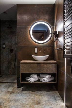 A modern bathroom with a round mirror, a vessel sink, and a towel shelf. - Hotel M23 (Katowice)
