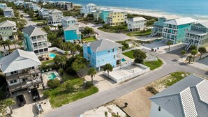 A coastal residential area with multiple two-story houses, a beach, and a clear view of the ocean.