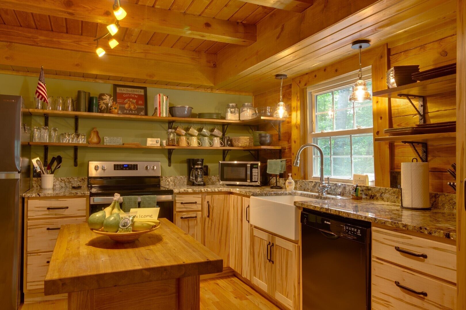 A cozy kitchen with wooden cabinets, a granite countertop, a stainless steel oven, a microwave, and a sink.