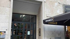 A building entrance with a glass door and a sign reading "Boudele".