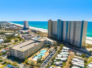 Ein Küstenhotel mit mehreren Hochhäusern, einem Schwimmbad und direktem Strandzugang.