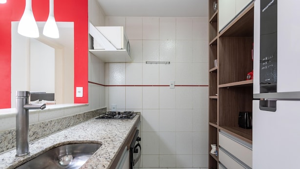 Een keuken met een granieten aanrecht, een roestvrijstalen spoelbak en een gasfornuis.