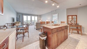 A spacious kitchen with a central island, dining area with chairs, and a view to the outside. - LTW 421 in PCB! Beautiful Views 3 Bed 3 Bath Sleeps 8 (Panama City Beach)