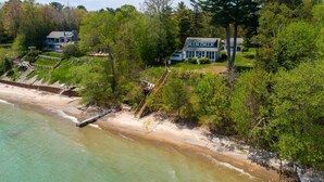 A coastal property with a beach, a staircase leading to a house, and surrounding greenery. - Waterfront Homes in Lexington  (Lexington)