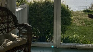 A room with a large window overlooking a grassy area and a body of water. - Waterfront Homes in Lexington  (Lexington)