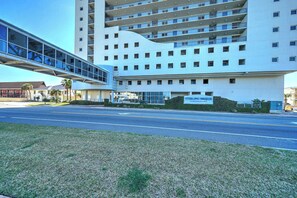 A modern building with multiple floors, a glass walkway, and a sign indicating 'Sterling Heights Condominiums'.