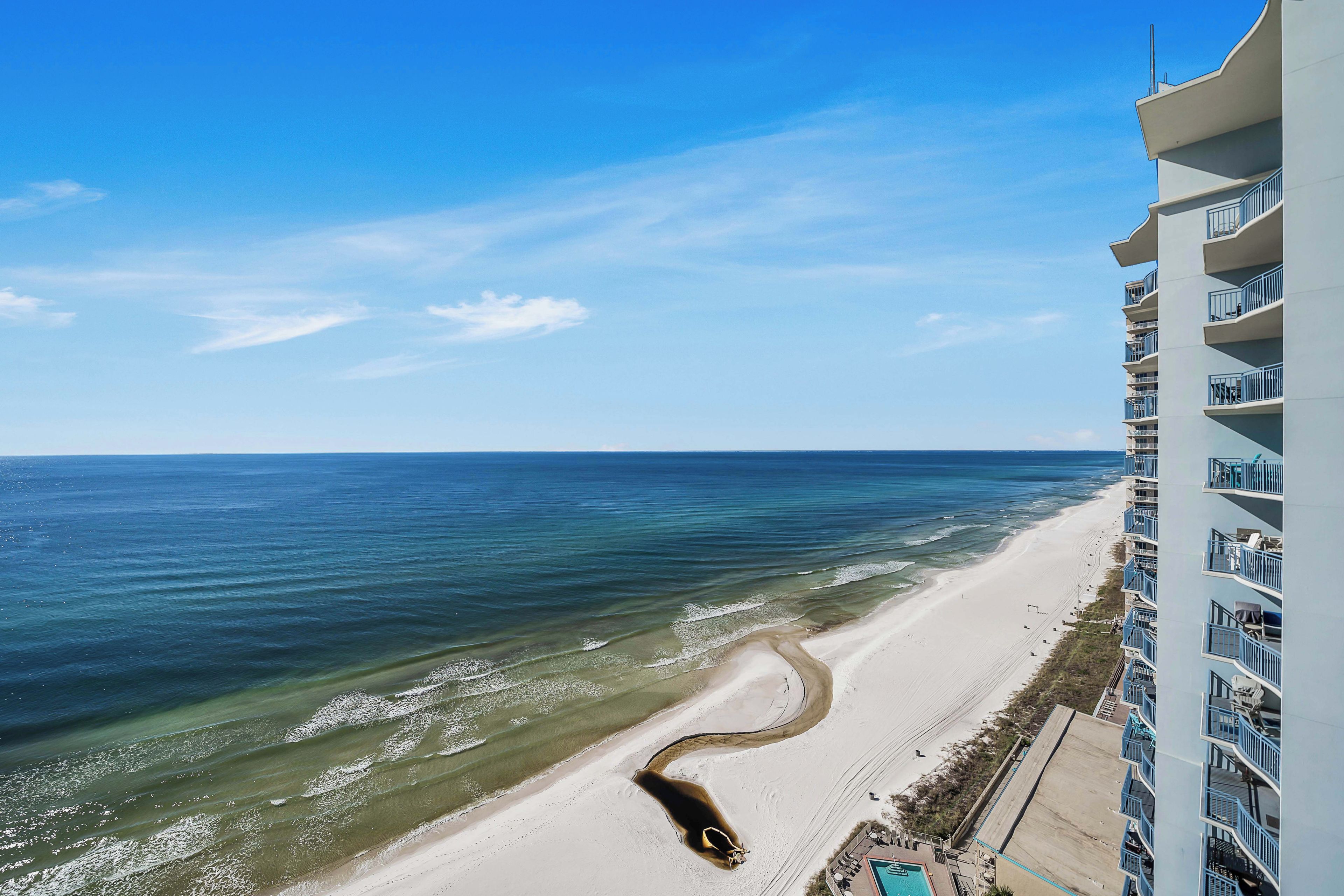 Ein Strandhotel mit Pool, Blick auf den Ozean und einem Sandstrand.