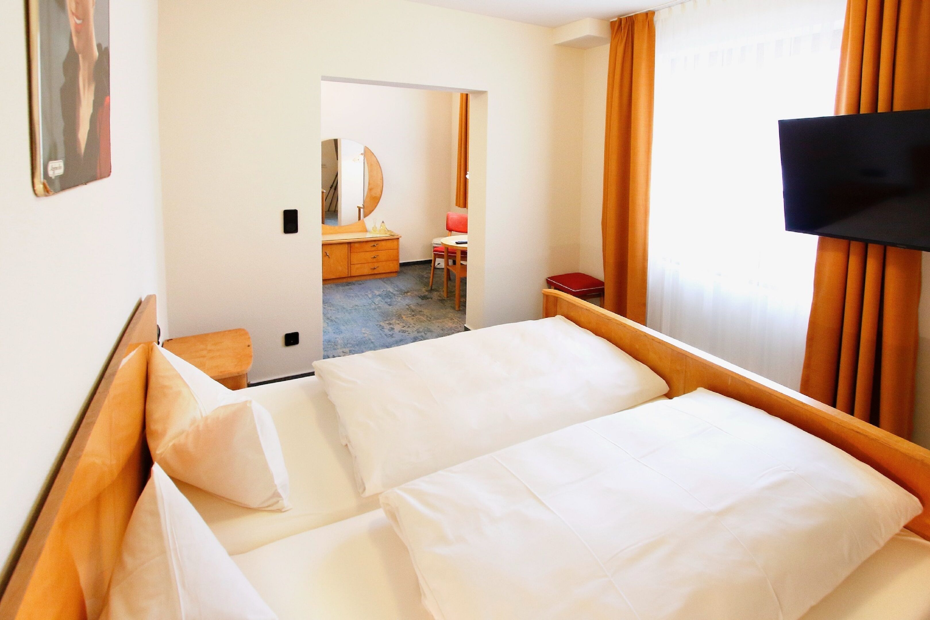 A hotel room with a bed, a television, a desk, and a chair.