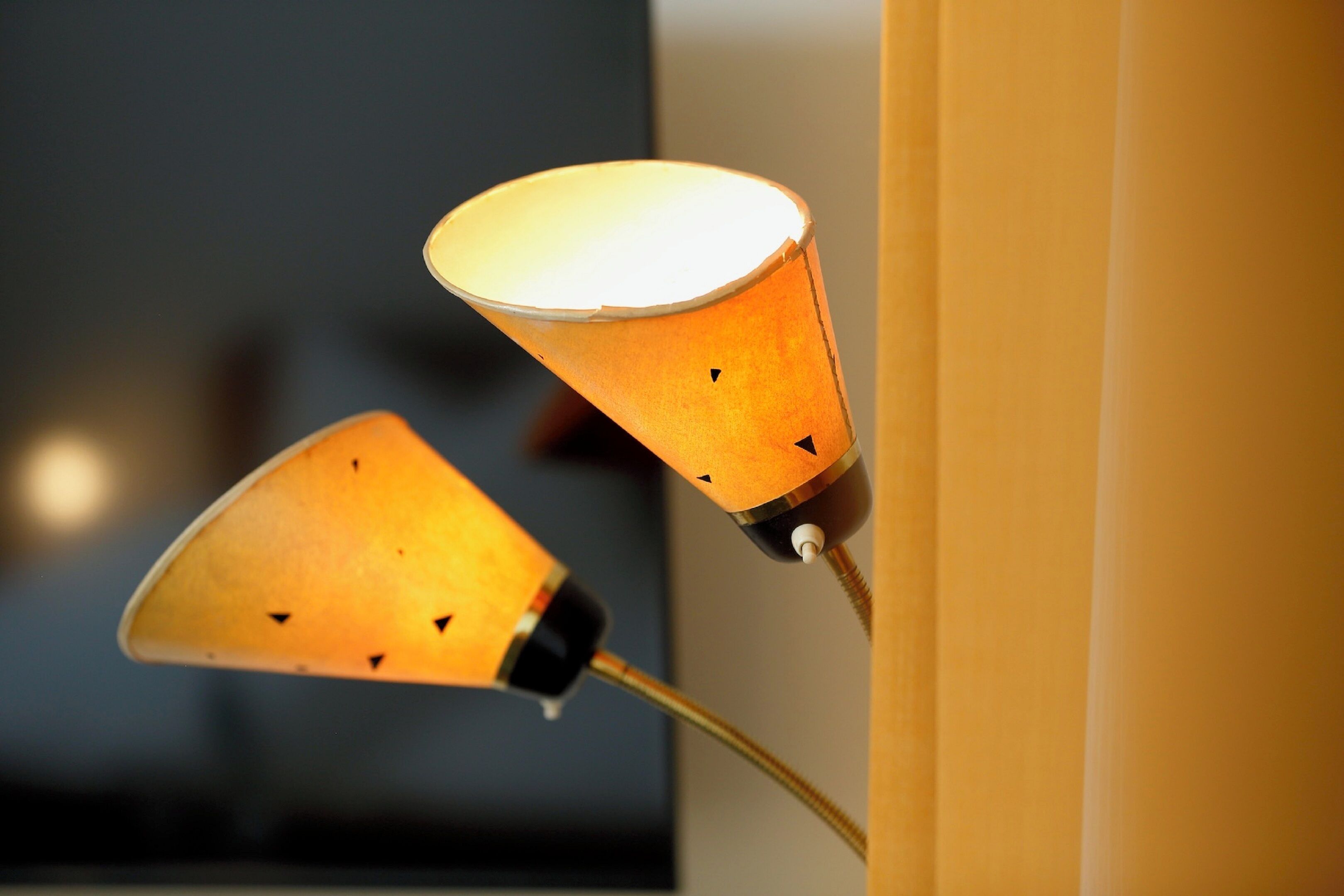 Eine Wandleuchte mit kegelförmigem Lampenschirm.