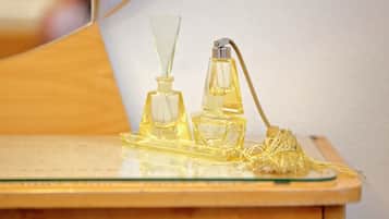 Two perfume bottles on a wooden surface with a glass tray.