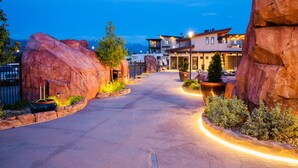 A hotel entrance with a paved driveway, large rock formations, and a building with multiple stories and outdoor seating. - Sage Creek at Moab Tunnel Arch Hideaway (Moab)