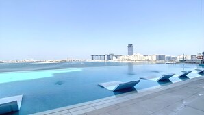 Ein Pool auf dem Dach mit freiem Blick auf die Stadt und eine entfernte Brücke.