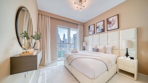 Ein modernes Schlafzimmer mit einem großen Bett, einem Nachttisch, einem Spiegel und Blick auf die Stadt.