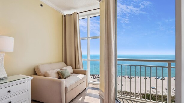 A balcony with a view of the beach and ocean.