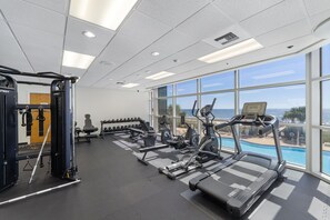 A gym with treadmills, dumbbells, and a squat rack.