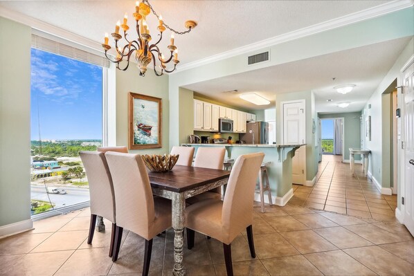 A dining area with a chandelier, a painting of a boat, and a view of the ocean. - NEW LISTING!!! Palacio 706 - Beachfront - NO HASSLE CHECK OUT (Perdido Key)