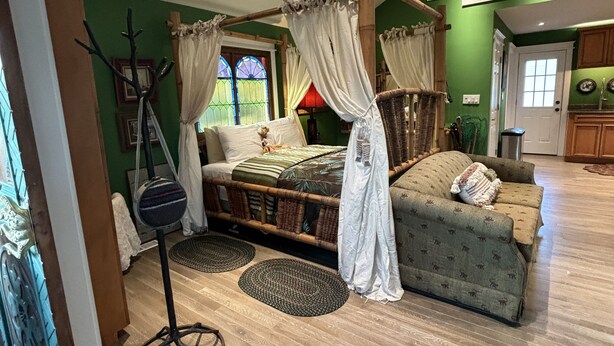 A room with a four-poster bed, a sofa, and a dining area. - Renovated Fisherman’s Cottage  (Lower Township)