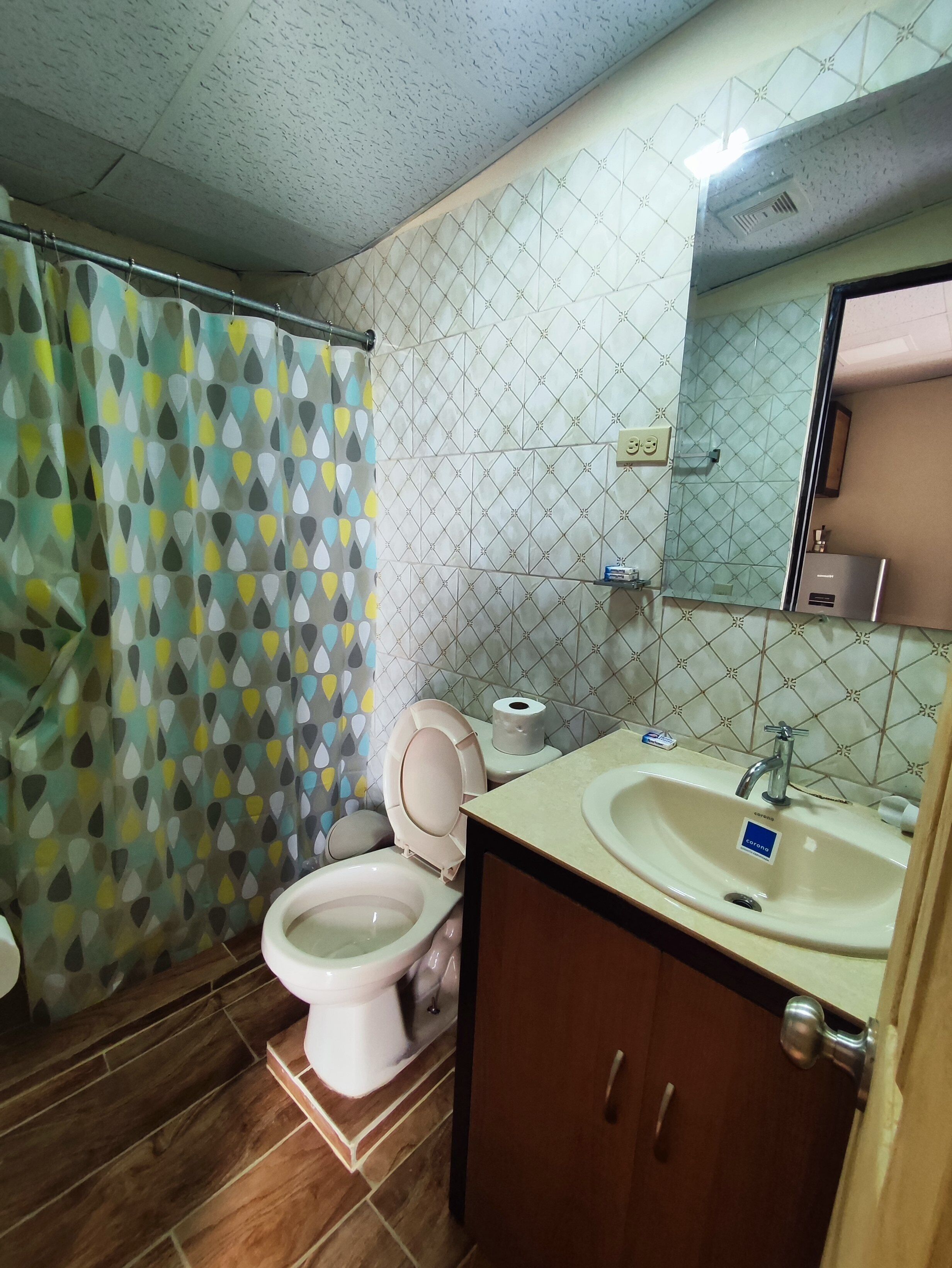 Un baño con inodoro, lavabo y cortina de ducha.