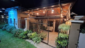 A covered outdoor area with a metal fence, potted plants, and a bench. - Aires frescos de Boquete (Alto Boquete)