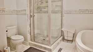 A bathroom with a glass-enclosed shower, a toilet, and a bathtub. - 1 Bedroom Loft in Downtown Defiance! (Defiance)