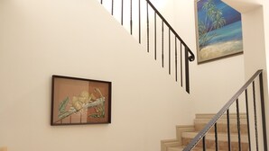 A staircase with a metal railing, a framed painting of a leopard and a cub, and another painting of a beach scene. - Housekeeping BBQ Pool 4 TVs Garden Oceanview Villa Casa Sol Azul (Tempate)