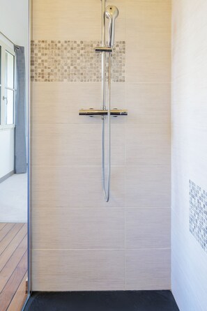 Een douche, handdoeken, zeep, shampoo