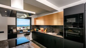 A modern kitchen with a view, stainless steel appliances, and a minimalist design.
