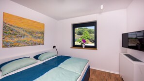 A bedroom with a bed, a window with a view, a painting, and a television. - Villa Mar by Villas Guide (Palit)