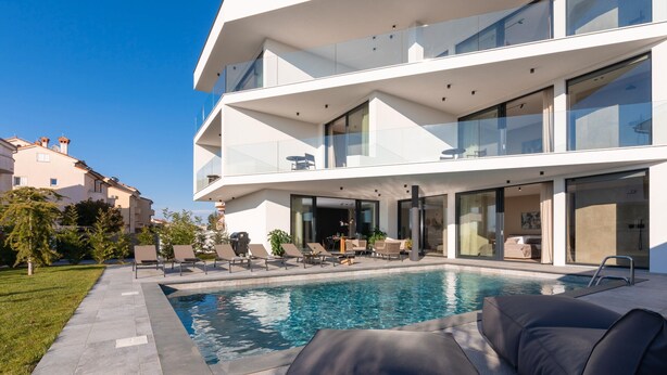 A modern multi-story building with a swimming pool, outdoor seating, and glass balconies. - Villa Aruna by Villas Guide (Pula)