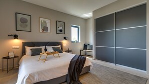 Una camera da letto moderna con un letto grande, comodini, una finestra e una porta scorrevole.