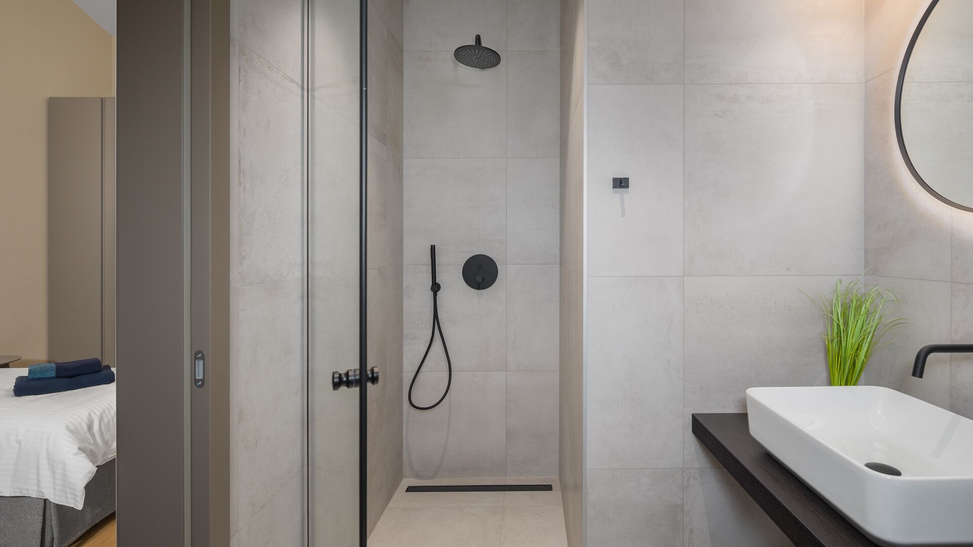 A modern bathroom with a shower, a sink, and a mirror.