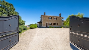 A gravel driveway leading to a two-story stone house with a tiled roof, surrounded by greenery. - Villa St. Martina by Villas Guide (Kringa)