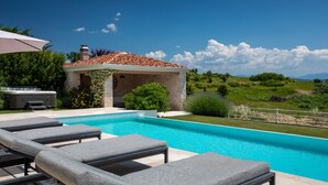 A swimming pool with lounge chairs, a hot tub, and a stone building with a tiled roof. - Villa Monte by Villas Guide (Vižinada)