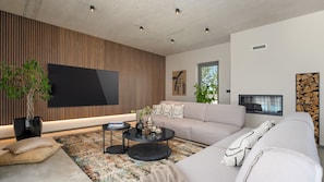 A modern living room with a large flat-screen TV, a sofa, a coffee table, and a potted plant. - Villa Lipa Tree by Villas Guide (Novigrad)