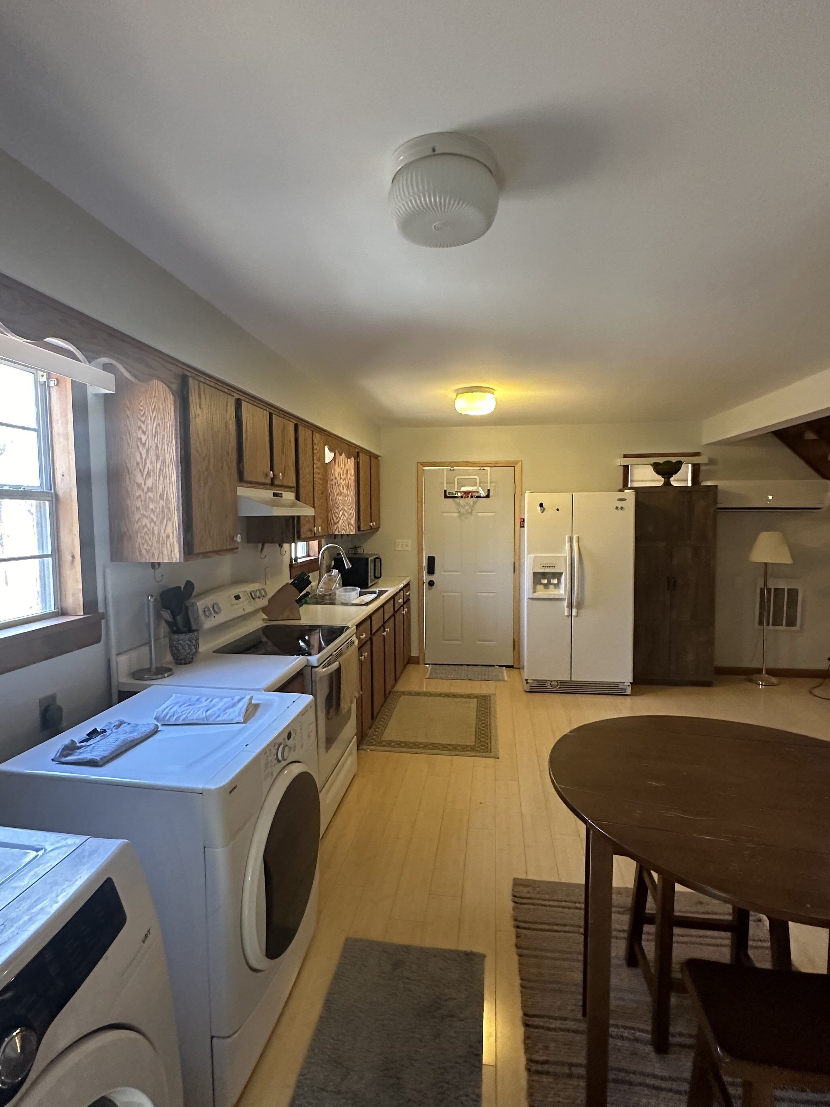 Una cocina compacta con armarios de madera, horno empotrado, microondas y refrigerador.