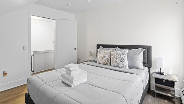 Un dormitorio moderno con una cama grande, una mesita de noche y un buró.