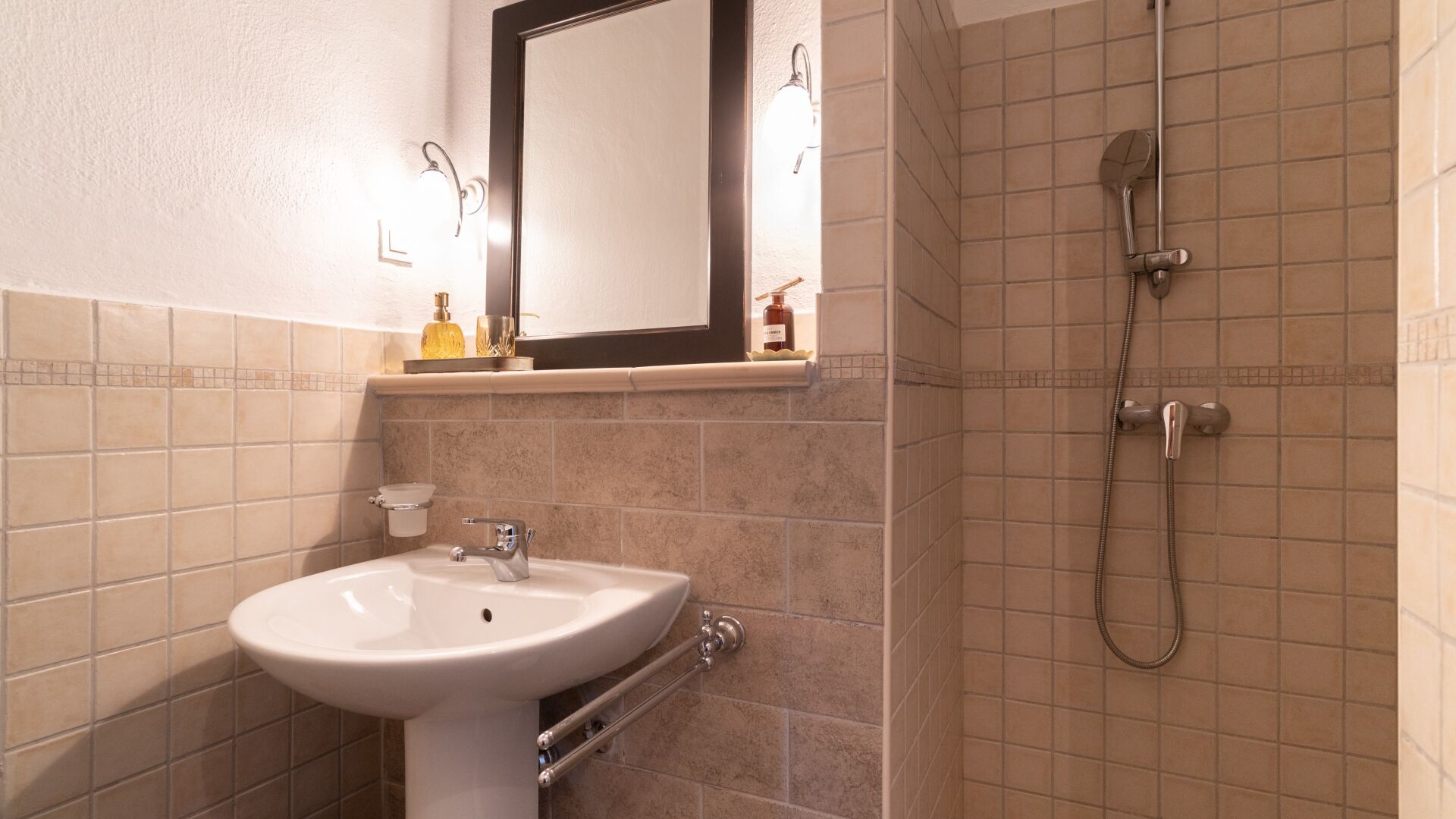 A bathroom with a sink, mirror, and shower.