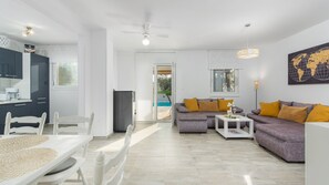 A modern living room with a sofa, coffee table, and dining area.