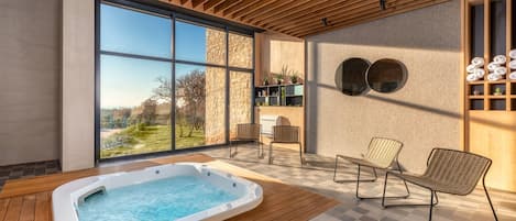 A modern indoor pool area with a hot tub, wicker chairs, and a view of the outdoors.