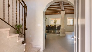 A staircase with a wrought iron railing leading to a dining area with a table and chairs. - Villa Kave by Villas Guide (Grožnjan)
